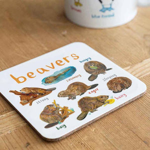 Coaster featuring illustrations of beavers on a white background. Each beaver is labelled, while the text 'Beavers' is printed on the top. The coaster sits on a wooden surface.
