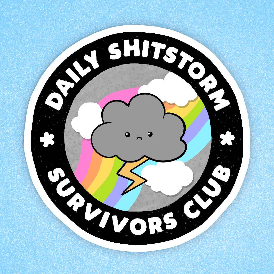 A circular sticker with a white border around the edge, featuring an illustration of a grey storm cloud with a sad face in the centre. The storm cloud sits on top of some clouds, a rainbow and a lightening bolt. The text 'Daily Shitstorm Survivors Club' is printed within a black border, inside the outer white border. The sticker sits on a blue background. 