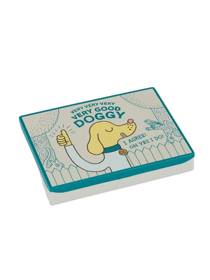Image of a pocket-sized storage tin featuring an illustration of a smiling yellow dog giving a thumbs up. The dog stands in front of a blue line drawing of a fence and trees against a beige-coloured background. The text 'Very very very very good doggy' is printed over the dog, while 'I agree! Oh yes I do!' is printed under the dog's face. The tin is shown on a white background. 