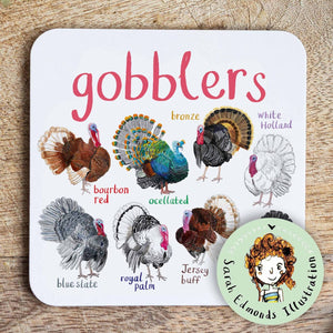 Coaster featuring illustrations of turkeys on a white background. Each turkey is labelled, while the text 'Gobblers' is printed on the top. The coaster sits on a wooden surface.