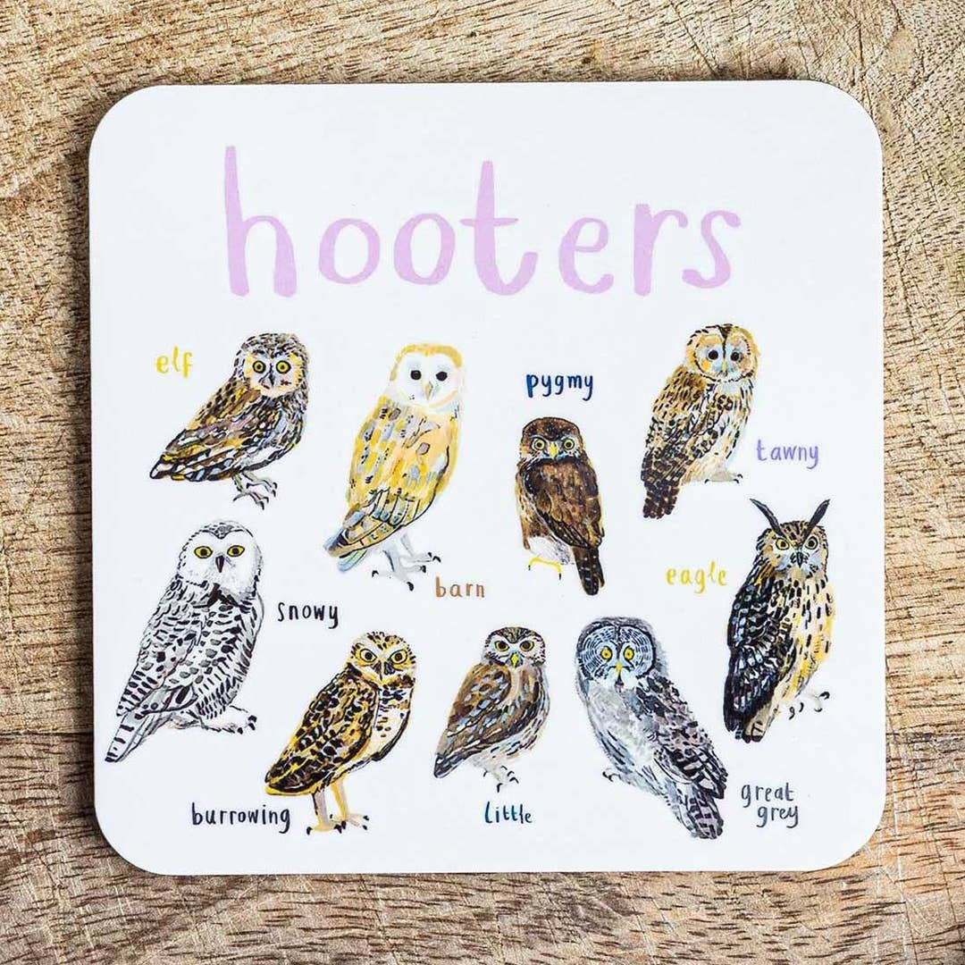 Coaster featuring illustrations of owls on a white background. Each owl is labelled, while the text 'Hooters' is printed on the top. The coaster sits on a wooden surface.