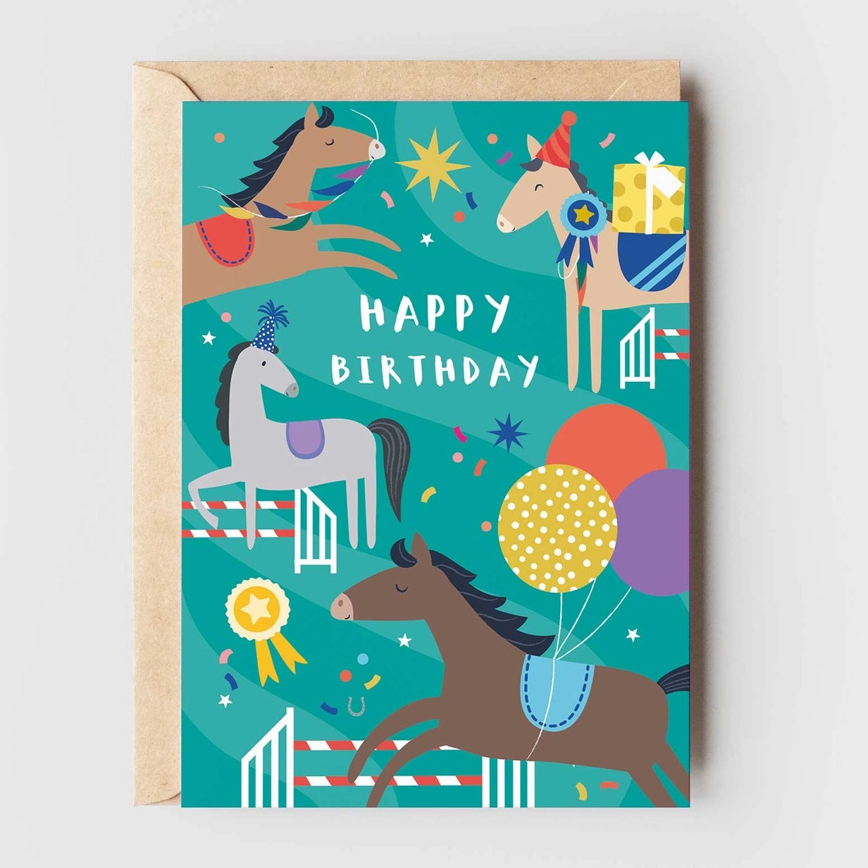 Greeting card featuring illustrations of horses wearing party hats and fences. One horse wears balloons tied around it's waist, another carries a gift box on it's back while another holds a garland in it's mouth as it jumps. The text 'Happy Birthday' is printed over the top centre of the card. 