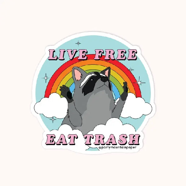 white die-cut sticker of a raccoon opening its arms in front of a rainbow. top text reads "live free". bottom text reads "eat trash"