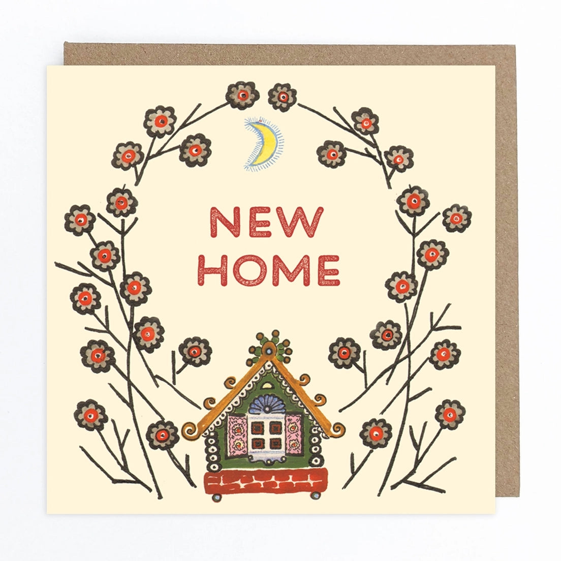 Greeting card featuring a folk art style illustration of a colourful house with elaborate decor and pink shutters on the window. An abstract flower design creates an arch over the house. Inside the arch, the text 'New Home' sits below an illustration of the moon on a cream coloured background.