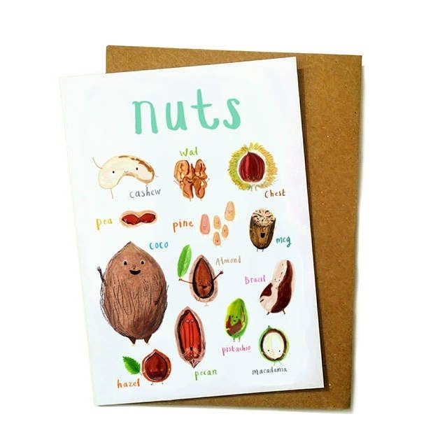 Greeting card featuring illustrations of nuts on a white background. The heading 'nuts' is printed at the top of the card while each of the images are labelled with smaller text. The card lies on top of a brown envelope on a white surface.