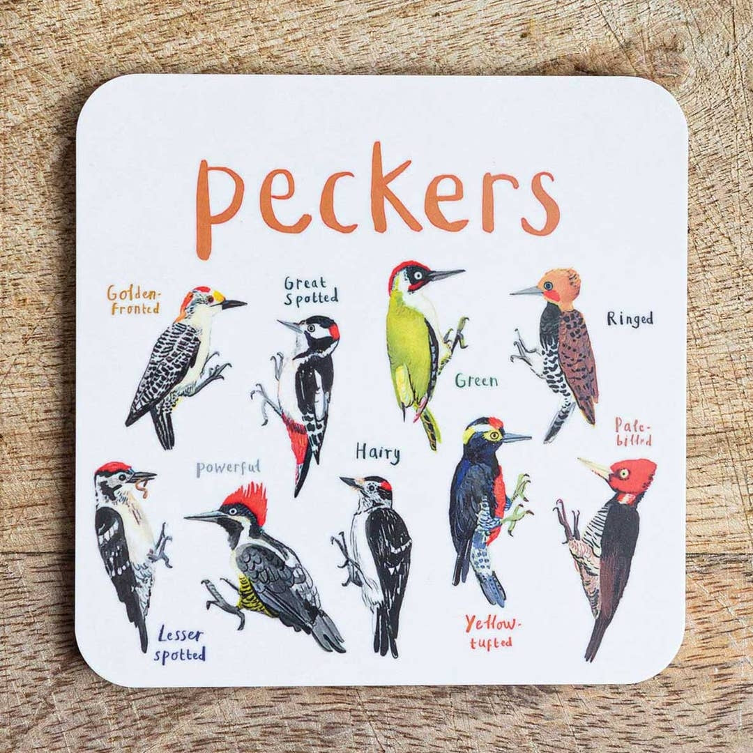 Coaster featuring illustrations of birds on a white background. Each bird is labelled, while the text 'Peckers' is printed on the top. The coaster sits on a wooden surface.