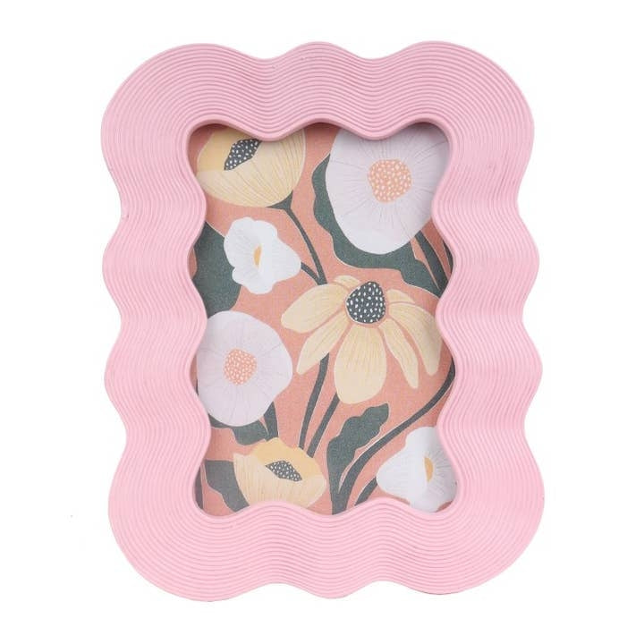 A pink rectangular shaped photo frame with a wavy shape and texture around the border. A floral design sits inside the frame. 