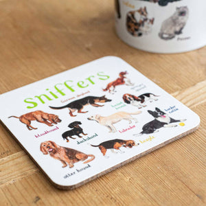 Coaster featuring illustrations of different dog breeds on a white background. Each dog is labelled with their breed while the text 'sniffers' is printed on the top. The coaster sits on a wooden surface.