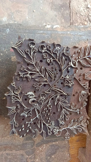 Decorative wooden stamp with intricate floral design.
