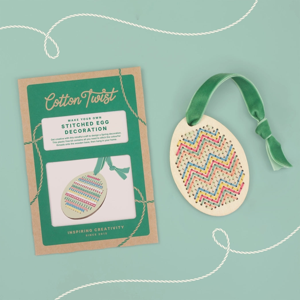 Cotton Twist stitched egg decoration with packaging on a blue background.