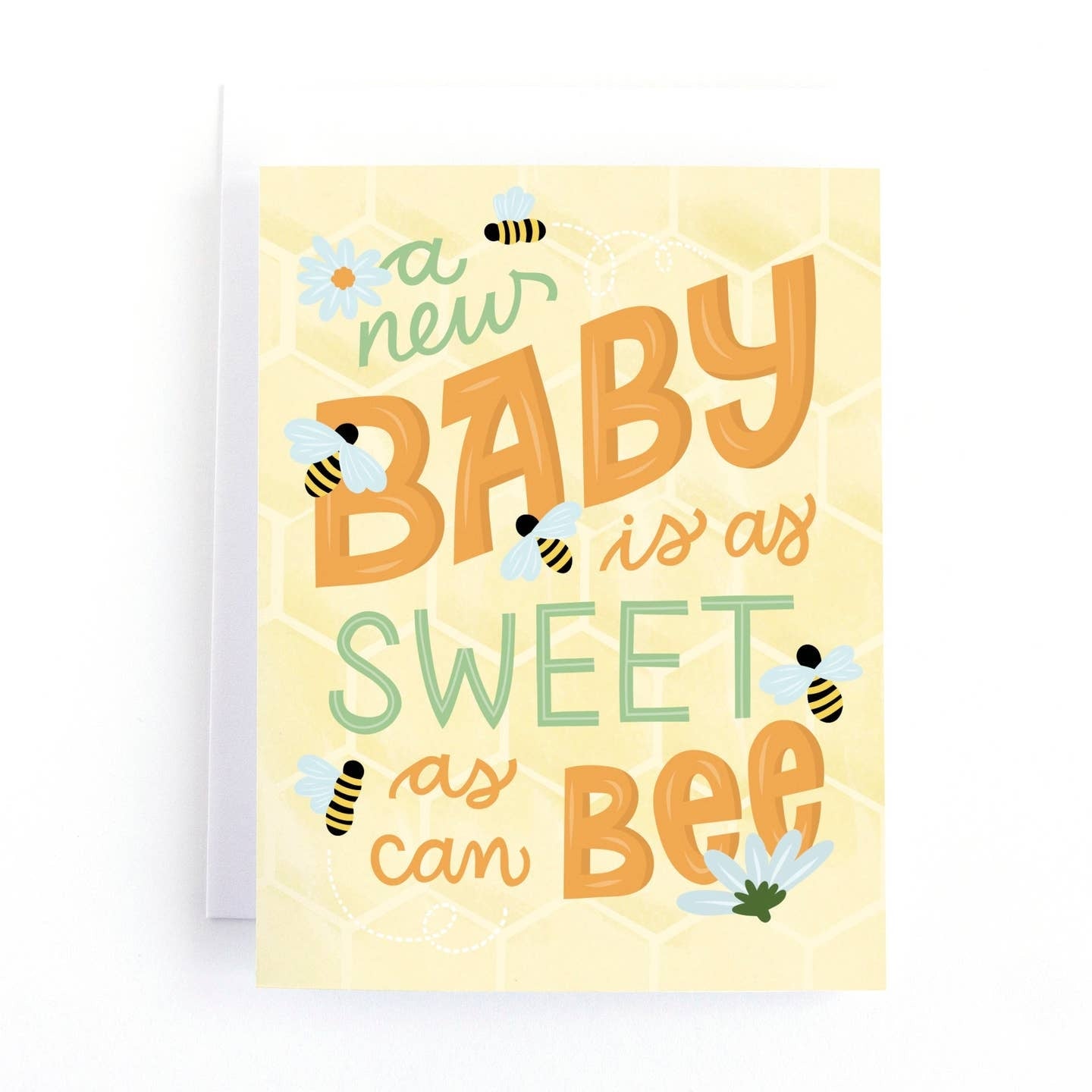 Greeting card featuring illustrations of bees and flowers on a yellow background with a honeycomb pattern. The text 'a new baby is as sweet as can bee' is printed across the front of the card. 