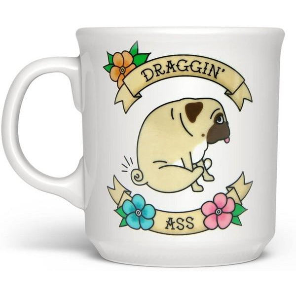 white mug with a stylized design of a pug dragging its butt. two flower-adorned banners frame the dog. on them are written "draggin'" and "ass" in a serif font